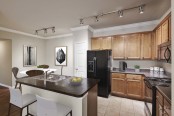 Kitchen with black appliances granite style countertops island and crown molding