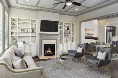 Townhome living room with hardwood flooring, built-in shelving, and high ceilings with ceiling fan