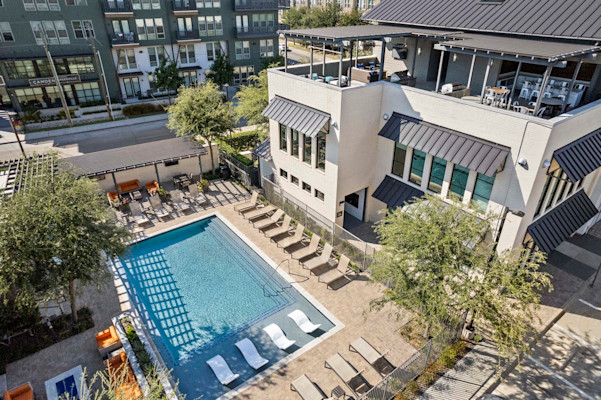 Aerial view of Villas pool and amenity building with rooftop lounge at Camden Greenville