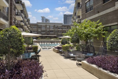 Poolside lounge with seating and umbrellas at Camden Victory Park apartments in Dallas, TX