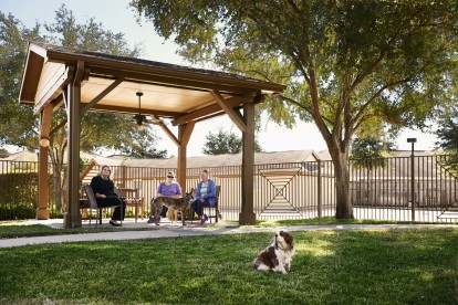 Private onsite fenced dog park with covered seating area