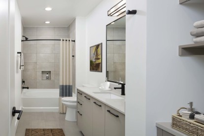 Warm modern finishes bathroom with quartz countertops and soaking tub