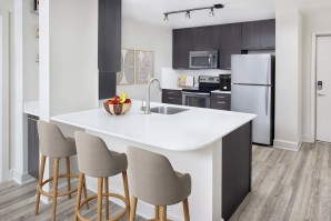 Kitchen with bar seating at Camden North Quarter apartments in Orlando, FL