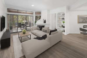 Living room with light gray wood-style floors, fireplace and large windows showing a spacious patio at Camden Gaines Ranch