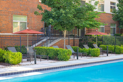 Individual poolside seating areas with umbrellas at Camden Franklin Park apartments in Franklin, TN