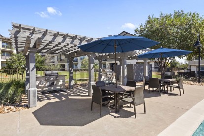 Poolside grills and covered seating at Camden Cedar Hills apartments in Austin, TX