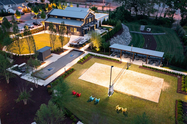 Aerial view of event lawn and sand volleyball court at twilight at Camden West Nashville apartments in Nashville, TN