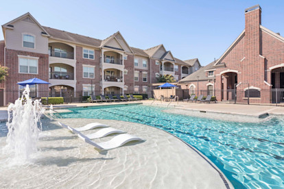 Resort-style pool with water features and sun loungers at Camden Cypress Creek Apartments in Cypress, Tx