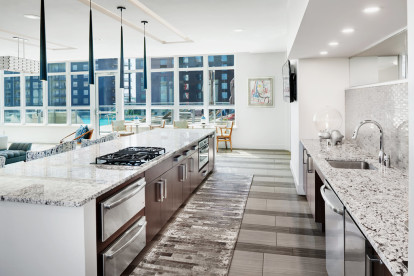 Resident clubroom kitchen overlooking rooftop pool