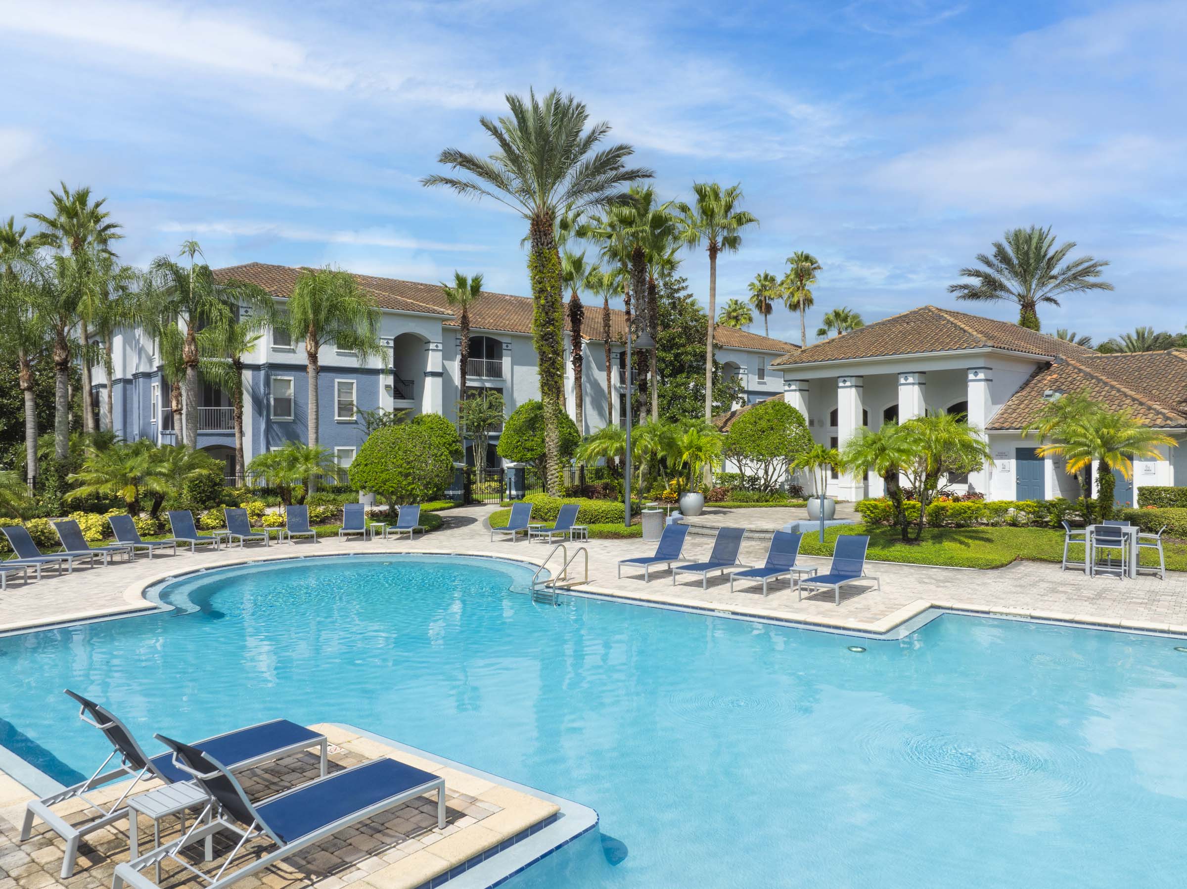 Pool surrounded by beautiful tropical landscaping at Camden World Gateway apartments in Orlando, FL