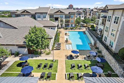 Resort-style pool and poolside yard lounge at Camden La Frontera apartments in Round Rock, TX