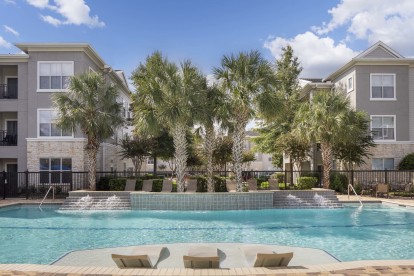 Resort-style pool with lounge chairs at Camden Spring Creek Apartments in Spring, Texas 