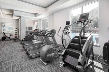 Two Fitness centers with cardio equipment including Peloton, Stairmaster, and treadmills at Camden City Centre Apartments in Midtown Houston, Tx 