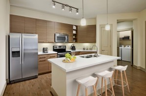 Kitchen and laundry with island white quartz countertops and stainless steel appliances