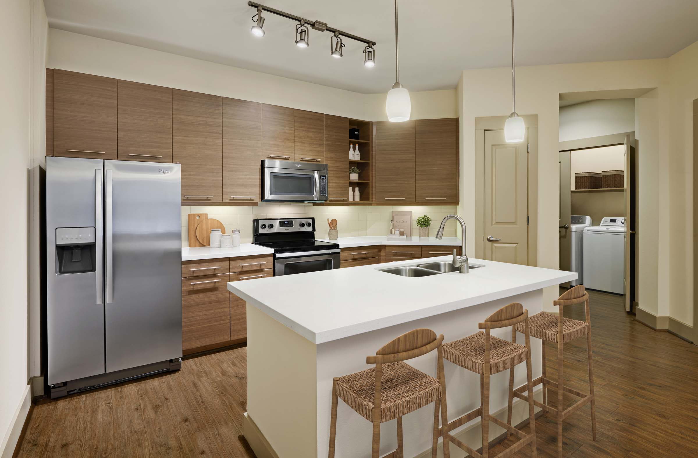 Kitchen and laundry with island white quartz countertops and stainless steel appliances