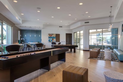 Resident clubhouse with shuffleboard and kitchen and dining seating