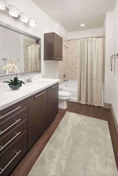 Bathroom with white countertops, a large soaking bathtub and stand up shower