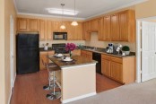 Kitchen with large island, granite countertops and black appliances