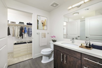 Luxury bathrooms with white quartz countertops, nickel fixtures, and ensuite walk-in closets with wooden shelves and rods