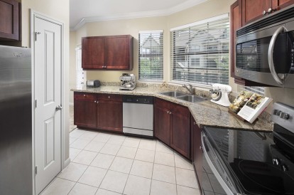 Estate style kitchen with chestnut cabinets tile floors stainless steel appliances and glass cooktop