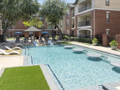 Pool 2 with in-water loungers and tables and a beach entry at Camden Farmers Market apartments in Dallas, TX