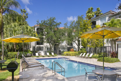 Swimming pool and seating areas at Camden Aventura apartments in Aventura, Florida.