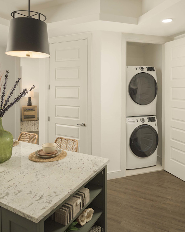 Stackable washer and dryer near the kitchen island at Camden Gilbert apartment homes in Gilbert, AZ