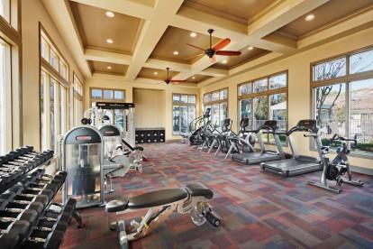 Fitness center with cardio equipment and free weights at Camden Northpointe Apartments in Tomball, TX