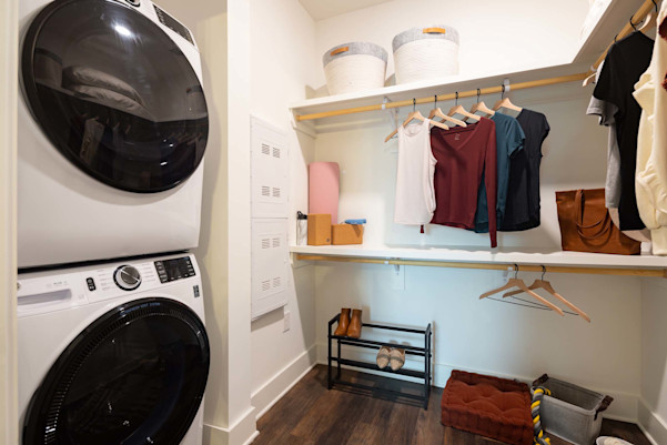 Spacious closet with built-in wood shelves and stackable washer and dryer at Camden West Nashville apartments in Nashville, TN