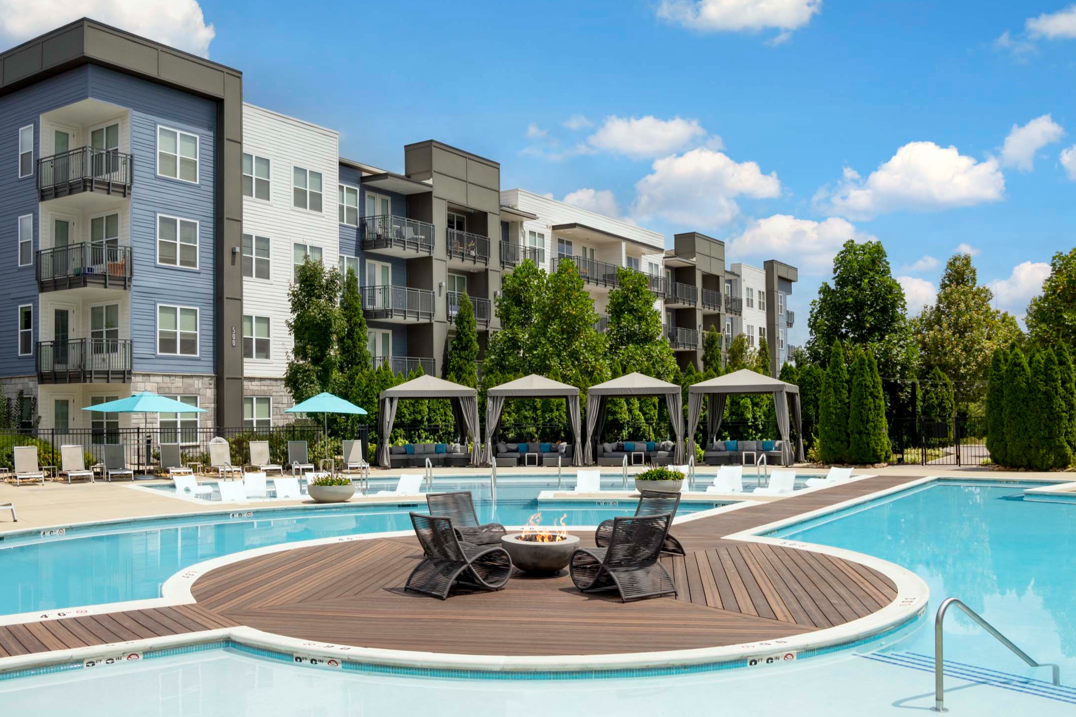 Firepit and seating on the deck in the middle of the pool at twilight at Camden West Nashville apartments in Nashville, TN