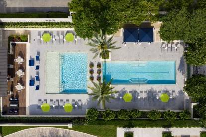 Two large pools with seating areas and beautiful landscaping