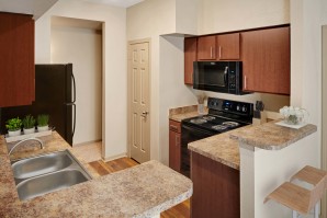 Kitchen with black and stainless appliances at Camden Stonebridge Apartments in Houston, TX