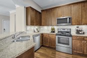 Spacious kitchen with granite countertops, subway tile backsplash, and hardwood-style flooring