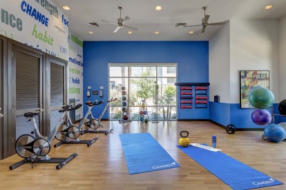 24-hour fitness center with spin bikes, stability balls, and space for pilates and yoga