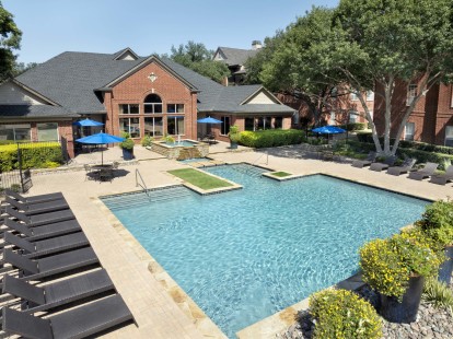 Resort-style pool lower level lined with lounge chairs at Camden Addison apartments in Addison, TX