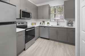Kitchen with gray cabinets, white quartz countertops and stainless steel appliances