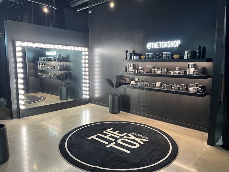 glam black and white decor and a large mirror with stage lighting surrounding the mirror, round carpet with The Tox nashville logo
