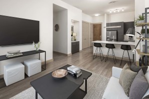 Living room and kitchen with entry nook and wood-style flooring at Camden Victory Park apartments in Dallas, TX