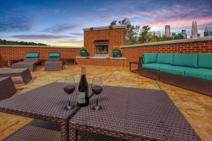 Rooftop terrace with lounge seating, fireplace, and skyline views