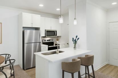 Renovated kitchen with white cabinets and white countertops at Camden Stoneleigh apartments in Austin, Tx