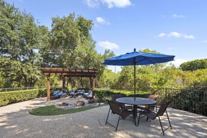 Poolside covered patio and table at Camden Legacy Creek apartments in Plano, TX