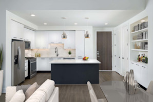 Bright contemporary finishes kitchen with island and gas range and goose neck faucet