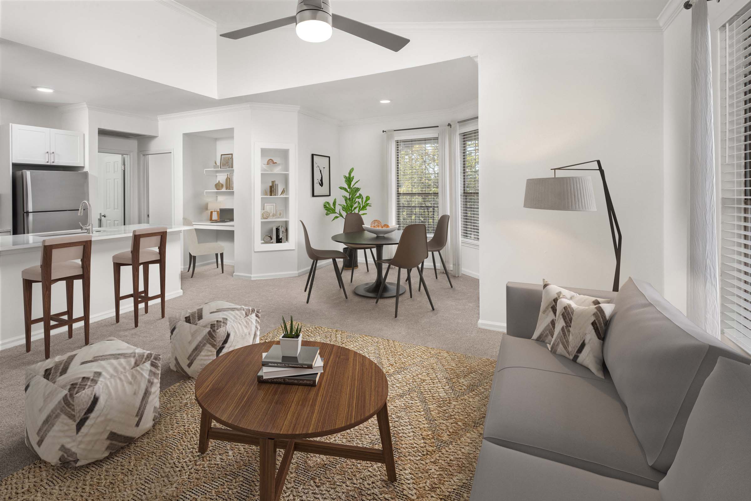 Living room, dining room and kitchen with extended ceiling and plush carpet at Camden Stoneleigh apartments in Austin, TX.