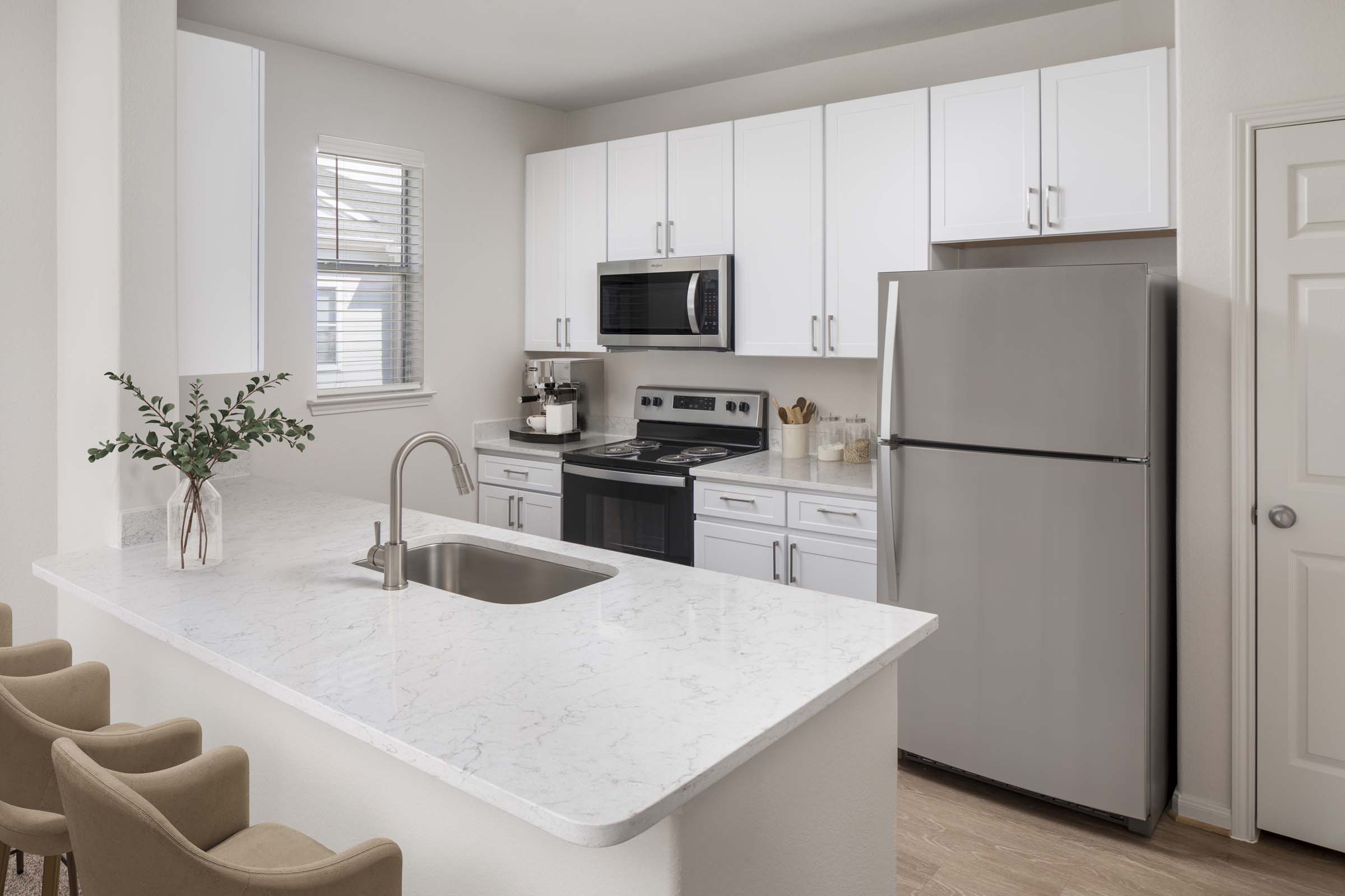 Kitchen with granite countertops, white cabinetry and stainless steel appliances at Camden Spring Creek Apartments in Spring, Texas