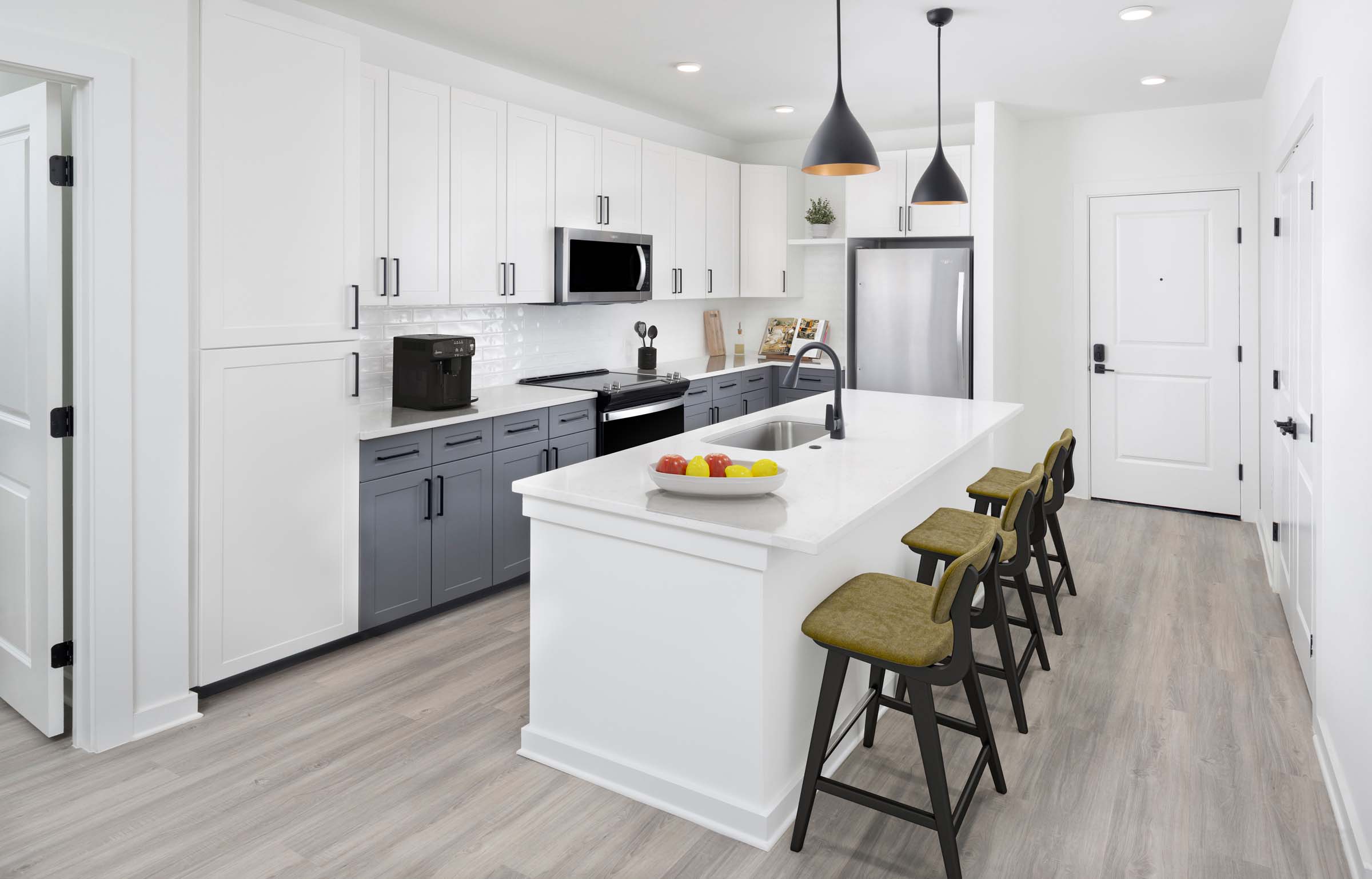 Two-bedroom spacious kitchen with quartz countertops and shaker-style cabinetry. 