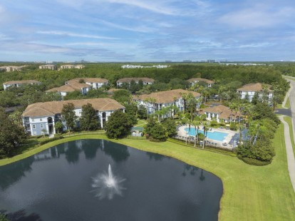 Community pool and lake at Camden World Gateway apartment community in Orlando, FL