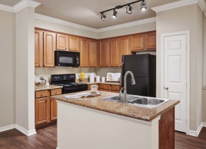 Kitchen wood like flooring and island counter at Camden Woodson Park in Houston, TX