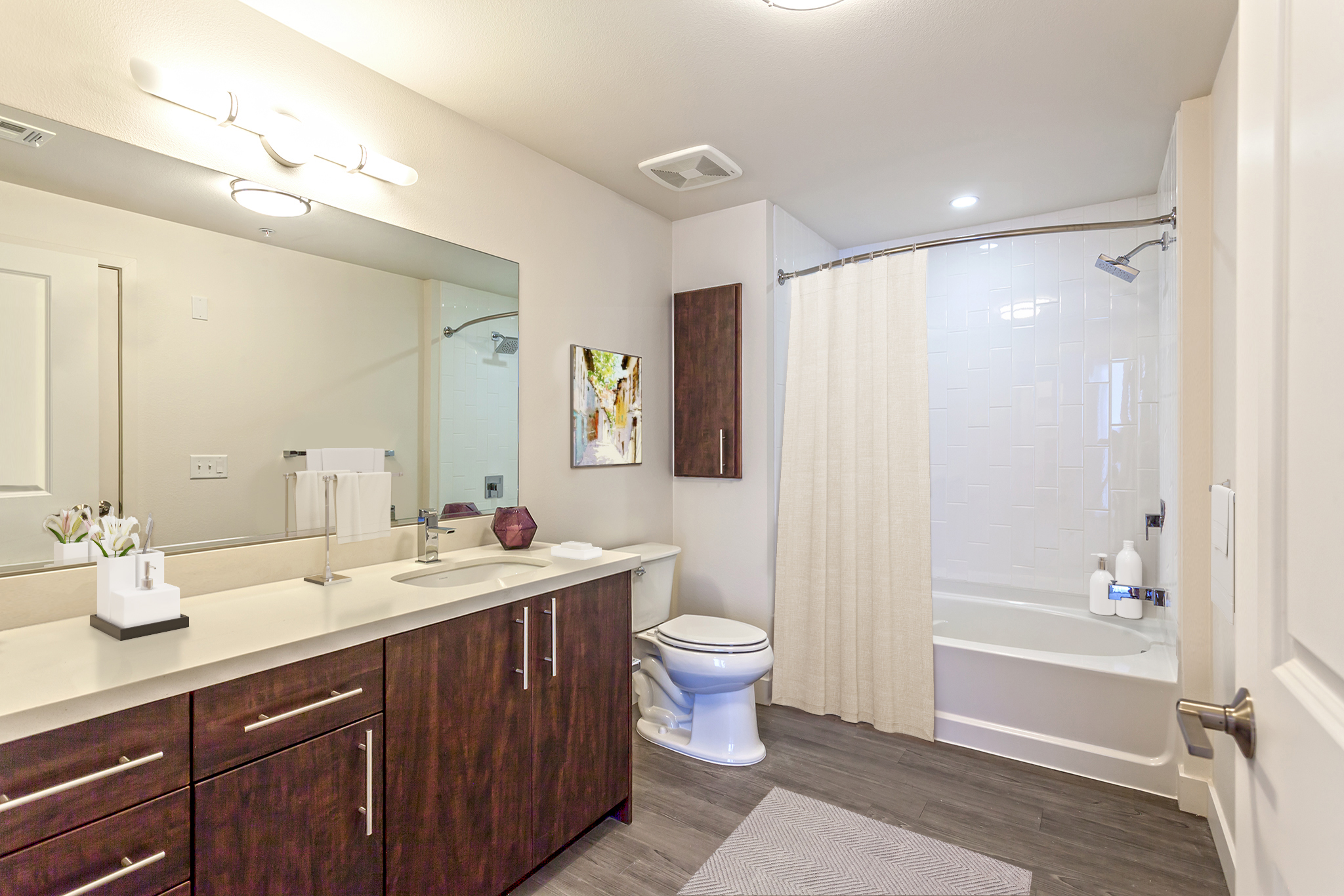 Large bathroom with quartz countertops linen cupboards and bathtub with curved shower rod