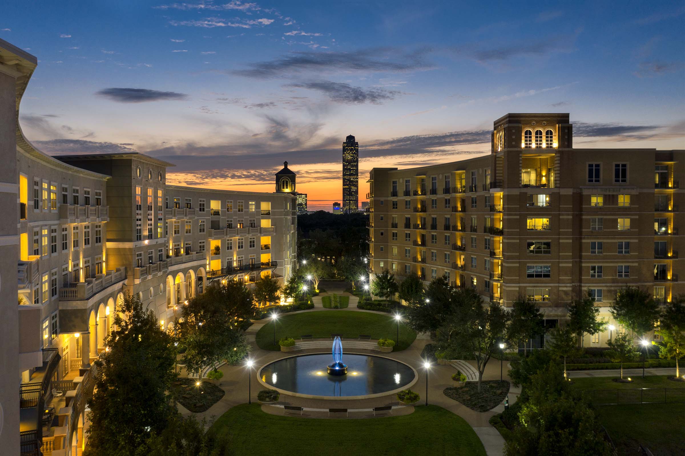 Exterior of building at night with water fountain courtyard