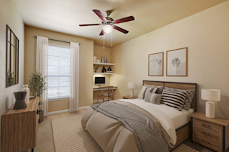 Bedroom with built-in desk and ceiling fan at Camden Brushy Creek apartments in Cedar Park, TX